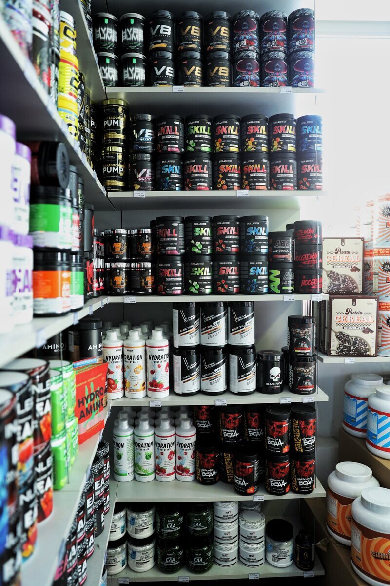 Regale im Triceps Store mit Pre-Workout, Aminosäuren und Supplements